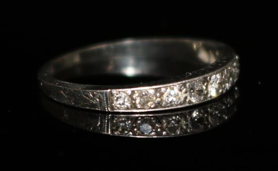 An early 20th century 18ct white gold and diamond half hoop ring, size M.